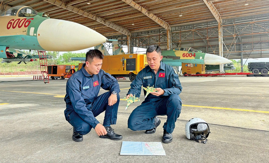 Nhờ nỗ lực học tập, rèn luyện, đại úy - phi công Nguyễn Hoàng Hải Quang (bên phải) đã đạt nhiều thành tích trong thực hiện nhiệm vụ. Ảnh: N.K