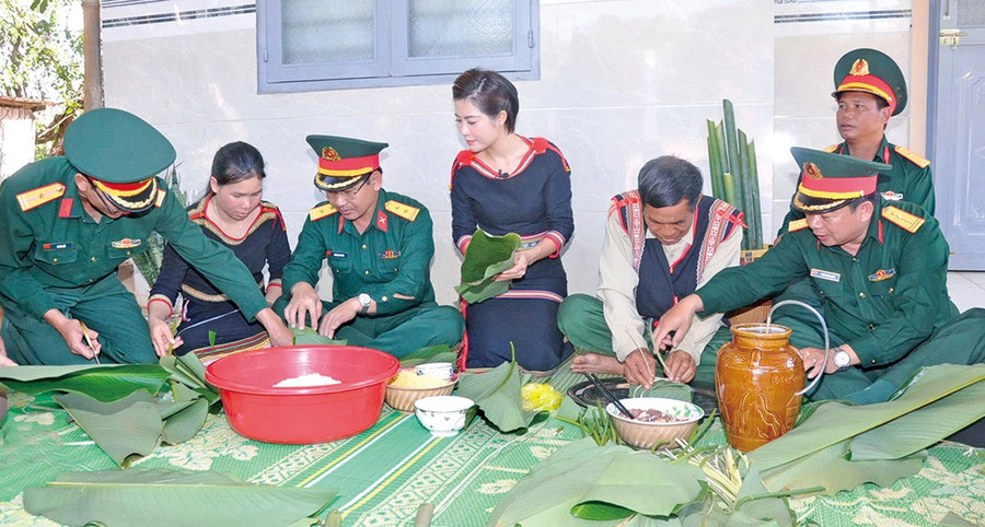 Cán bộ Binh đoàn 15 cùng người dân gói bánh chưng Tết. Ảnh: V.H