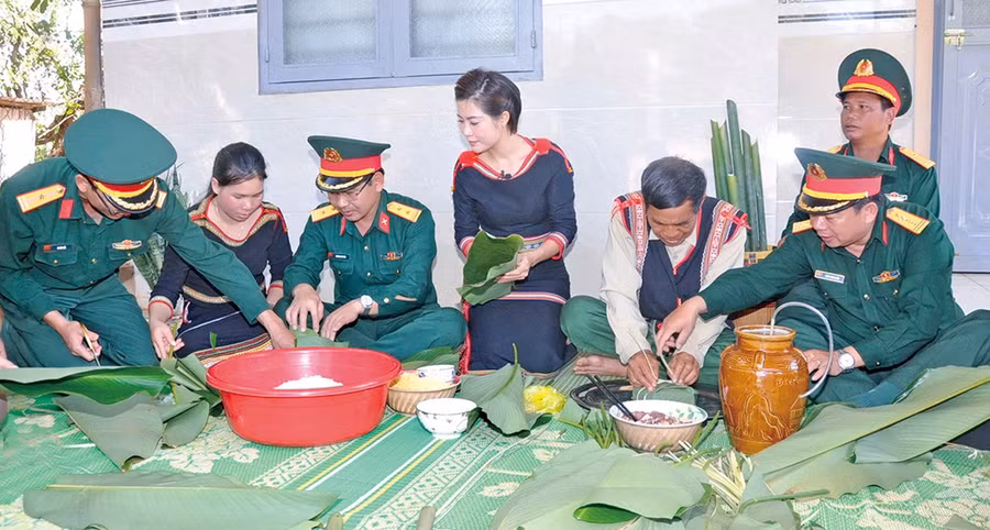 Cán bộ Binh đoàn 15 cùng người dân gói bánh chưng Tết. Ảnh: V.H