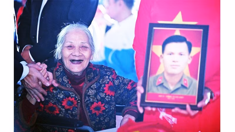 Khoảnh khắc bà Nguyễn Thị Bích cười tươi khi đón di ảnh của người bạn đời.