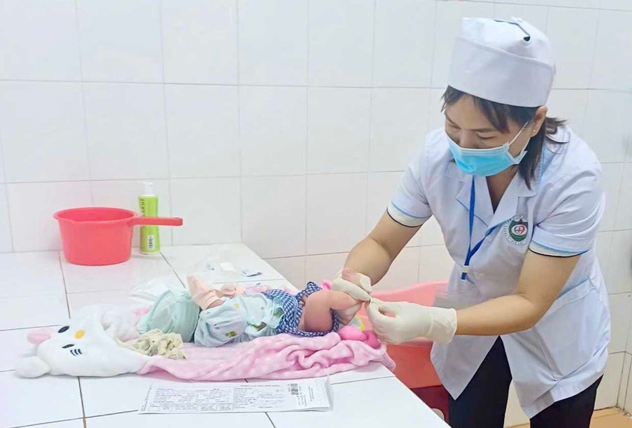 Nhân viên y tế lấy máu gót chân trẻ sơ sinh tại TTYT Đak Đoa. Ảnh: ĐVCC