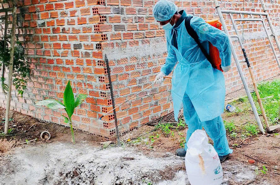 Nhân viên Trạm Chăn nuôi và Thú y khu vực 12 giúp người dân phun khử trùng khu vực chăn nuôi. Ảnh: Lê Nam