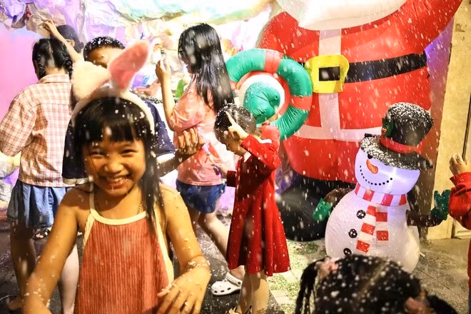Những em nhỏ háo hức vui chơi bên các đài phun tuyết.