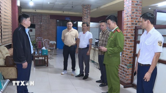 Cơ quan Cảnh sát điều tra thi hành Lệnh khám xét nơi làm việc của đối tượng Nguyễn Xuân Sơn. (Ảnh TTXVN phát)