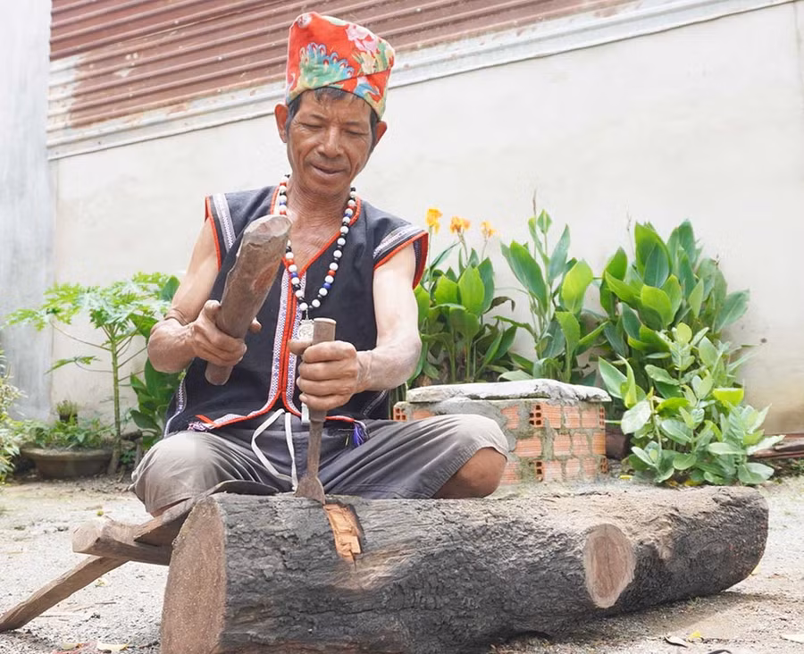 Ông Đinh Bri tạc tượng gỗ tại sân nhà.