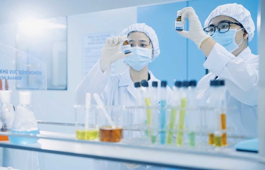 Die Mitarbeiter der Qualitätskontrolle von Bidiphar arbeiten mit Produkten zur Krebsbehandlung. Foto: DVCC Nhân viên kiểm soát chất lượng của Bidiphar thực hiện thao tác với các sản phẩm thuốc điều trị ung thư.