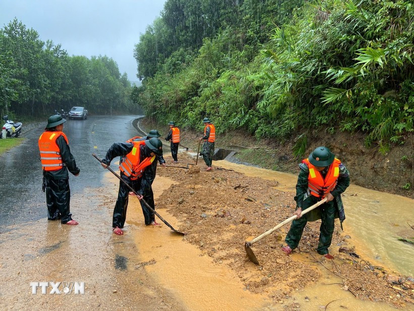 Bộ đội biên phòng thành phố Huế đào xúc đất đá, san gạt mặt đường bị sạt lở đất tại đèo Pê Kê, xã A Lưới 1. Ảnh: Mai Trang/Nguồn TTXVN sat-lo.jpg