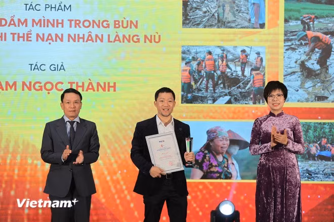 Ban Tổ chức trao Giải Nhất cho tác giả Phạm Ngọc Thành (giữa). (Ảnh: Hoài Nam/Vietnam+)