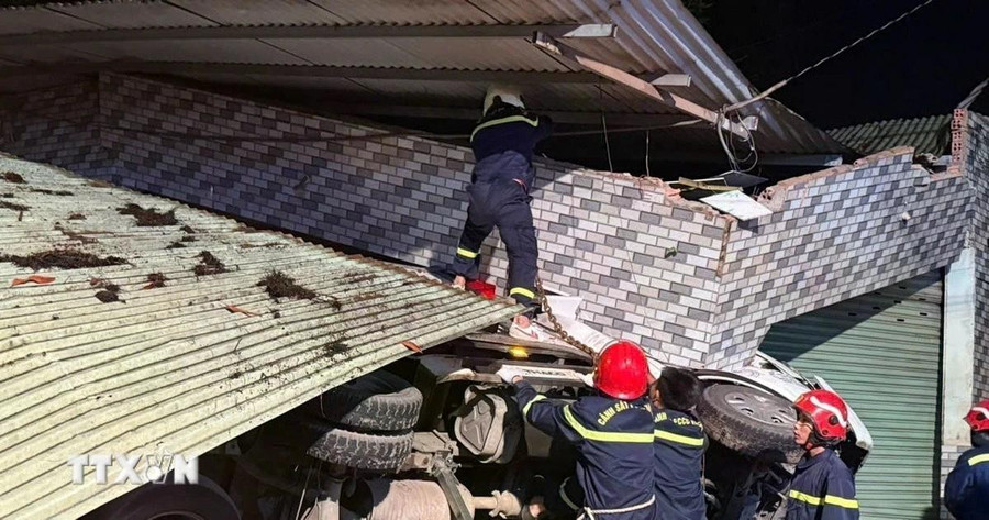 Nhiều chiến sỹ cảnh sát phòng cháy chữa cháy đến hiện trường tham gia cứu nạn cứu hộ. (Ảnh: TTXVN phát) dong-nai-xe-tai-dam-sap-nha-dan-tai-xe-mac-ket-trong-cabin-dd.jpg