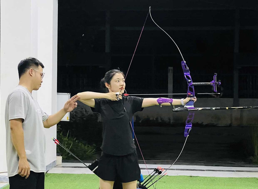 HLV Tiêu Viết Trường An (bìa trái) đang hướng dẫn học viên Nguyễn Thị Kiều Trang tập luyện cách bắn cung. Ảnh: M.N HLV Tiêu Viết Trường An (bìa trái) đang hướng dẫn học viên Nguyễn Thị Kiều Trang tập luyện cách bắn cung. Ảnh: M.N
