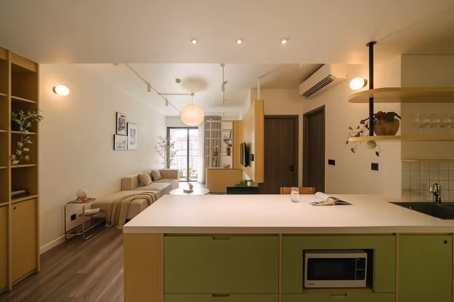 Từ cửa chính đi vào là khu vực đảo bếp đa năng, tủ âm tường sát trần cùng kệ âm nhẹ nhàng.