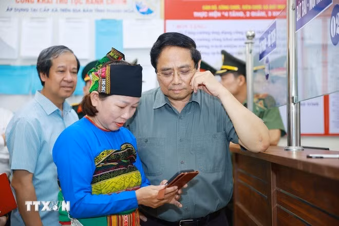 Thủ tướng Phạm Minh Chính thăm hỏi nhân dân đến làm thủ tục tại Trung tâm Phục vụ hành chính công xã Bát Mọt, tỉnh Thanh Hóa. (Ảnh: Dương Giang/TTXVN)