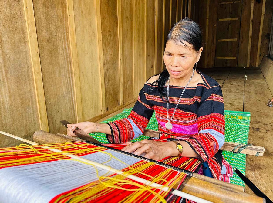 Bà Đinh Thị Chớ miệt mài ngồi bên hiên ngôi nhà sàn nhỏ dệt nên những tấm vải thổ cẩm rực rỡ sắc màu. Ảnh: D.Đ Bà Đinh Thị Chớ vẫn miệt mài ngồi bên hiên ngôi nhà sàn nhỏ dệt nên những tấm vải thổ cẩm rực rỡ sắc màu.
