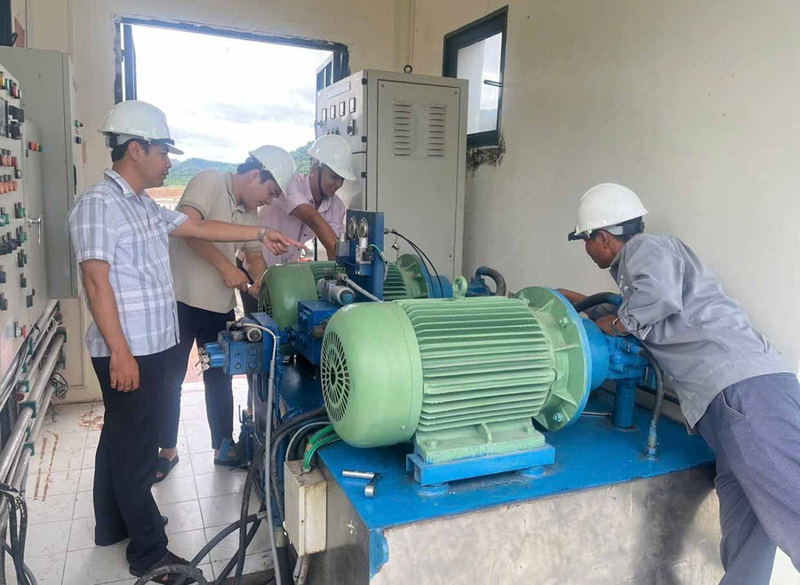 Arbetare på Dinh Binh Irrigation Enterprise kontrollerar och reparerar maskiner och utrustning för att driva projektet effektivt. Foto: T. Loi Công nhân Xí nghiệp Thủy lợi Định Bình kiểm tra, sửa chữa máy móc, trang thiết bị để vận hành hiệu quả công trình.