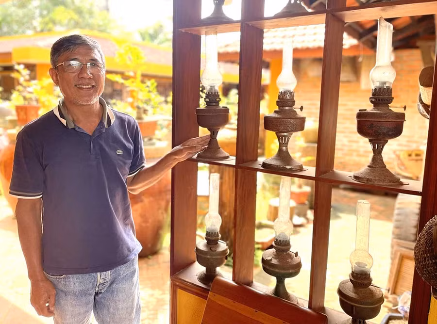 Chủ quán Vườn Mai bên những chiếc đèn dầu cũ kỹ. Ảnh: Phương Dung