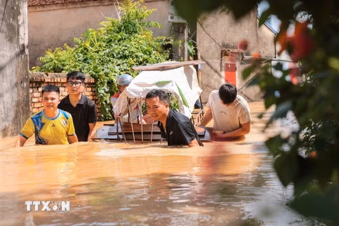 Người dân thôn Ngộ Đạo, xã Đa Phúc, Hà Nội, di chuyển tài sản khỏi vùng bị ngập. (Ảnh: Hoàng Hiếu/TTXVN)