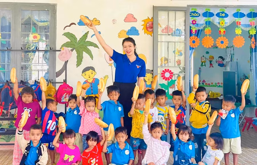 Niềm vui của học sinh điểm Trường Mẫu giáo Họa Mi khi được nhận bánh mì miễn phí từ Phó Bí thư Chi đoàn buôn Tơ Khế Nay Thị Thu Hà.