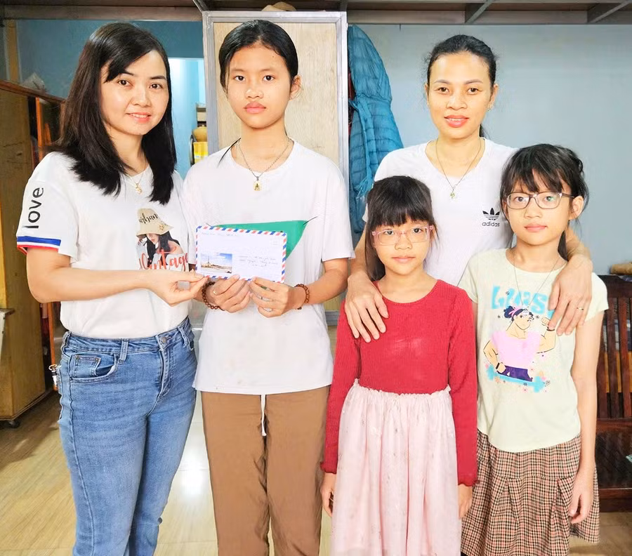 Chị Đỗ Thị Thùy – Trưởng nhóm Kết nối yêu thương (bìa trái) trao tiền hỗ trợ cho học sinh khó khăn.