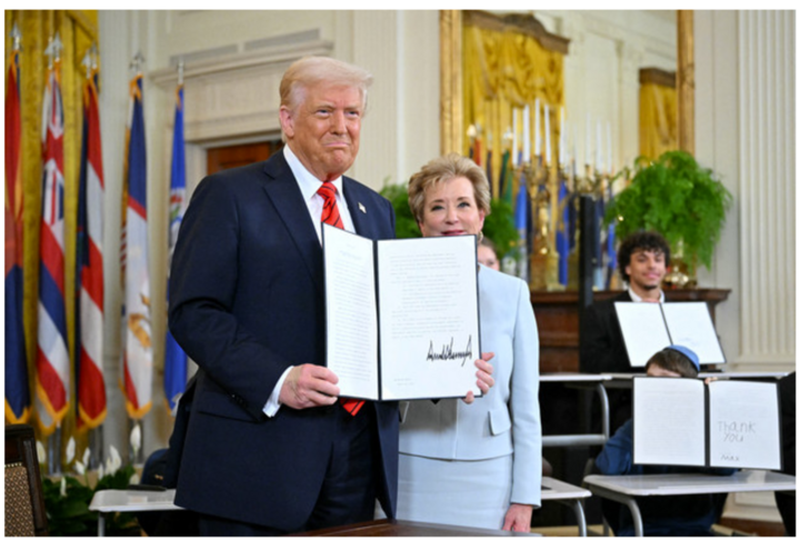Tổng thống Donald Trump cầm sắc lệnh hành pháp sau khi ký cùng với Bộ trưởng Giáo dục Linda McMahon. Ảnh: AFP/vtcnews.vn
