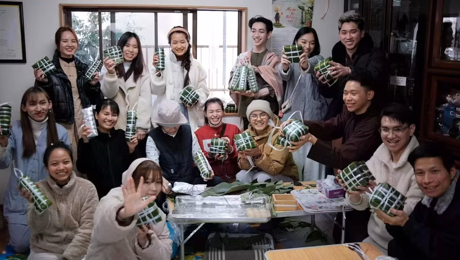Người trẻ sống ở Nhật quây quần gói bánh tét gìn giữ văn hóa tết cổ truyền. ẢNH: HUY HYUNH