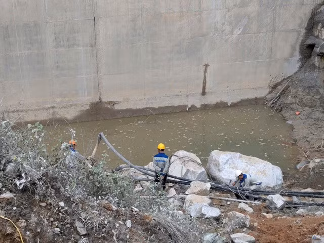 Lực lượng chức năng đã hút cạn nước tại chân đập thủy điện để tìm kiếm 2 nạn nhân