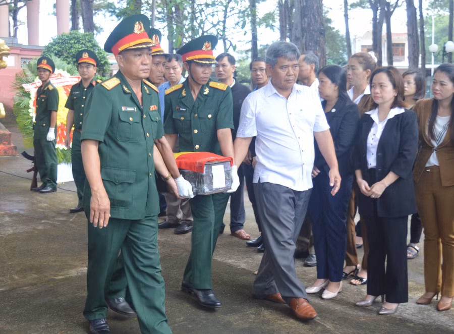 Chủ tịch Ủy ban MTTQ Việt Nam tỉnh Hồ Văn Điềm (bên phải) di chuyển hài cốt liệt sĩ lên xe về an táng tại quê nhà. Ảnh: Anh Huy