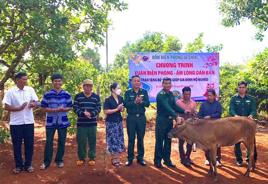 Cán bộ Đồn Biên phòng Ia Chía và đại diện chính quyền địa phương trao bò giống cho hộ ông Kih. Ảnh: Anh Huy