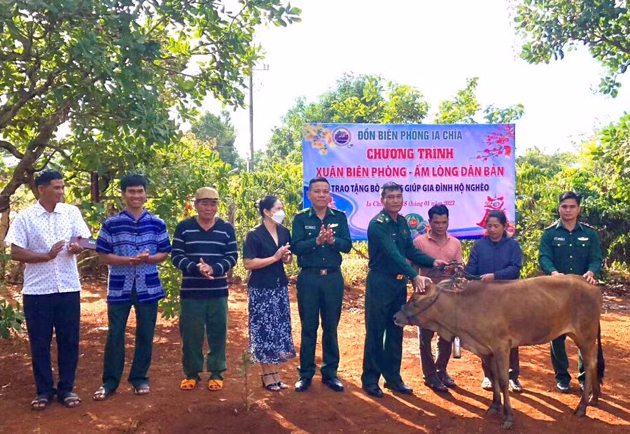 Cán bộ Đồn Biên phòng Ia Chía và đại diện chính quyền địa phương trao bò giống cho hộ ông Kih. Ảnh: Anh Huy