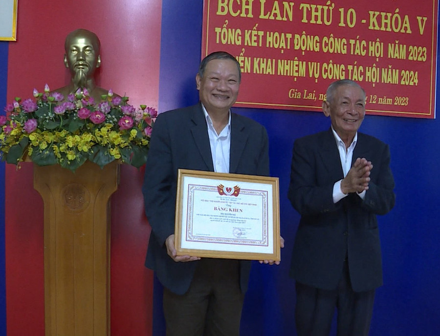 Ông Trương Đình Ba-Chủ tịch Hội Bảo trợ người khuyết tật và bảo vệ quyền trẻ em tỉnh trao bằng khen của Hội Bảo trợ người khuyết tật và bảo vệ quyền trẻ em Việt Nam cho ông Nguyễn Phú-Chủ tịch Hội Bảo trợ người khuyết tật và trẻ mồ côi thị xã Ayun Pa. Ảnh: Anh Huy