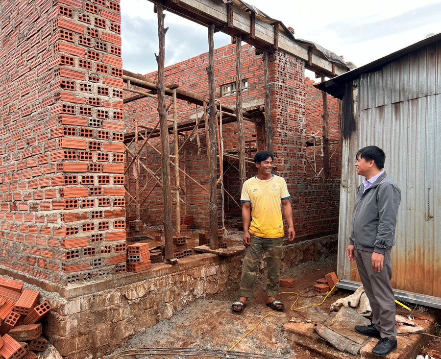 Bí thư chi bộ kiêm trưởng thôn Aron (áo vàng) trao đổi cùng lãnh đạo xã Đăk Djrăng về tiến độ xây dựng nhà ở cho hộ nghèo trong làng. Ảnh: P.D Bí thư chi bộ kiêm trưởng thôn Aron (áo vàng) trao đổi cùng lãnh đạo xã Đăk Djrăng về tiến độ xây dựng nhà ở cho hộ nghèo trong làng. Ảnh: P.D