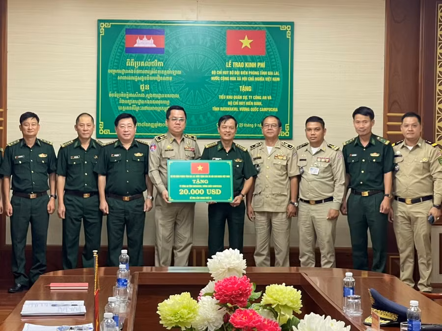 Đại tá Trần Tiến Hải-Chỉ huy trưởng Bộ Chỉ huy Biên phòng tỉnh (thứ 5 từ phải sang) trao bảng hỗ trợ kinh phí cho Đoàn đại biểu Ty Công an tỉnh Ratanakiri. Ảnh: Quốc Vinh