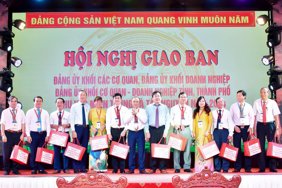 Bí thư Đảng ủy Khối các Cơ quan và Doanh nghiệp tỉnh Huỳnh Minh Thuận (thứ 7 từ trái sang) tặng quà các đơn vị dự hội nghị giao ban. Ảnh: Đức Thụy