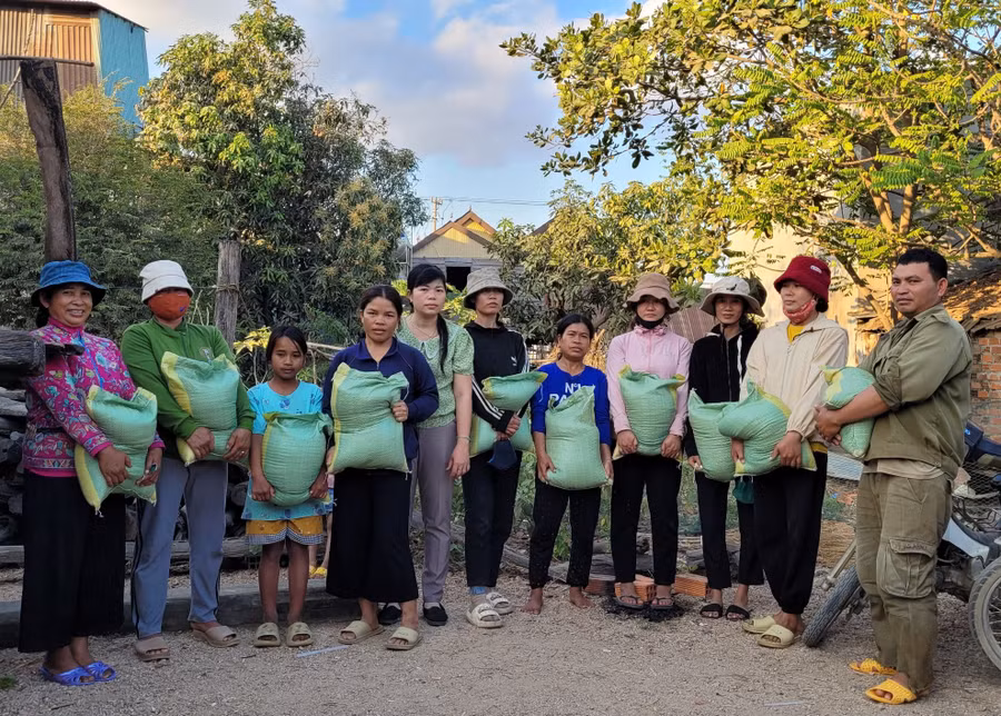 Chị Lợi (thứ 5 từ trái qua) tặng gạo cho hộ có hoàn cảnh khó khăn trong thôn. Ảnh: P.D