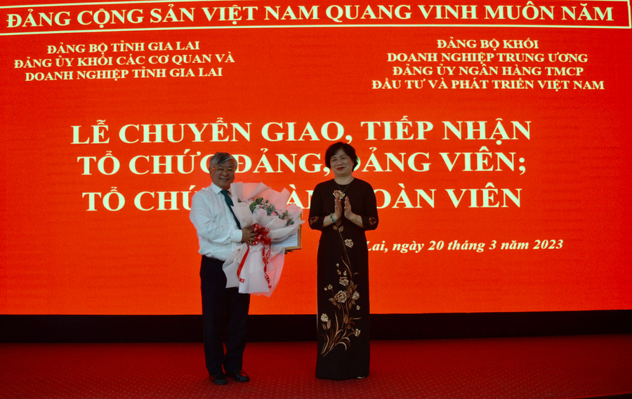 Bí thư Đảng ủy Khối các Cơ quan và Doanh nghiệp tỉnh Phạm Thị Tố Hải (bìa phải) trao quyết định và tặng hoa cho đại diện Đảng ủy BIDV. Ảnh: Anh Huy