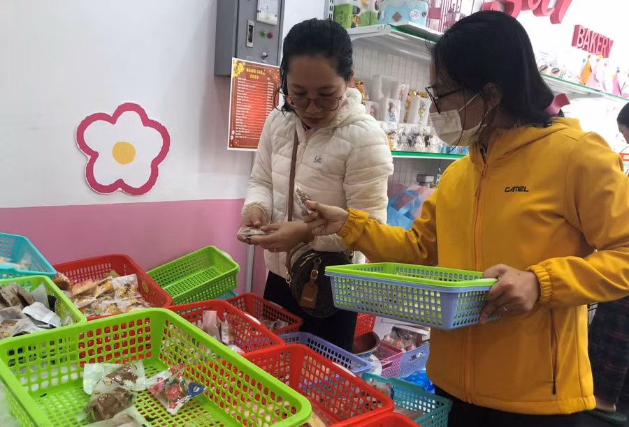 Chị Diễm (áo trắng) cùng bạn lựa chọn bánh kẹo Tết. Ảnh: Anh Huy