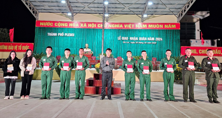 Chủ tịch UBND thành phố Đỗ Việt Hưng (thứ 6 từ trái sang) tặng quà động viên thanh niên lên đường nhập ngũ tại đêm hội. Ảnh: P.D