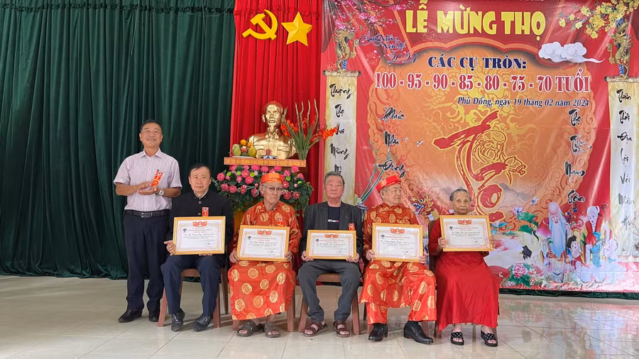 Chủ tịch UBND phường Phù Đổng trao bằng mừng thọ cho các cụ. Ảnh: P.D