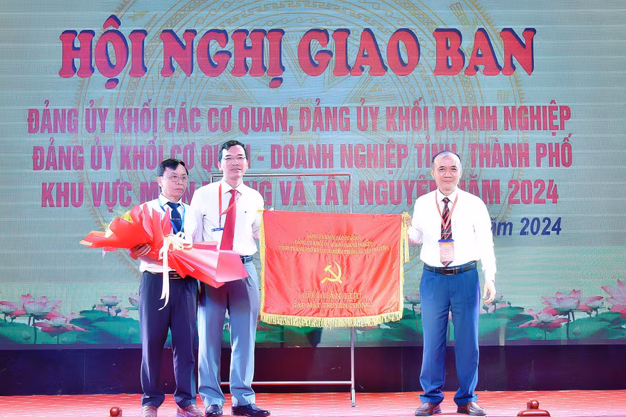 Bí thư Đảng ủy Khối các Cơ quan và Doanh nghiệp tỉnh Gia Lai (bên phải) trao cờ luân lưu gặp mặt truyền thống cho đại diện Thường trực Đảng ủy Khối các Cơ quan và Doanh nghiệp thành phố Đà Nẵng. Ảnh: Đức Thụy