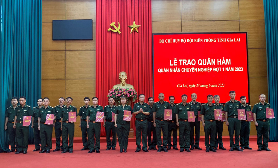 Đại tá Nguyễn Minh Tòng (hàng đầu, thứ 6 từ phải qua) trao quyết định nâng lương, thăng quân hàm cho các đồng chí quân nhân chuyên nghiệp. Ảnh: Kiên Quyết