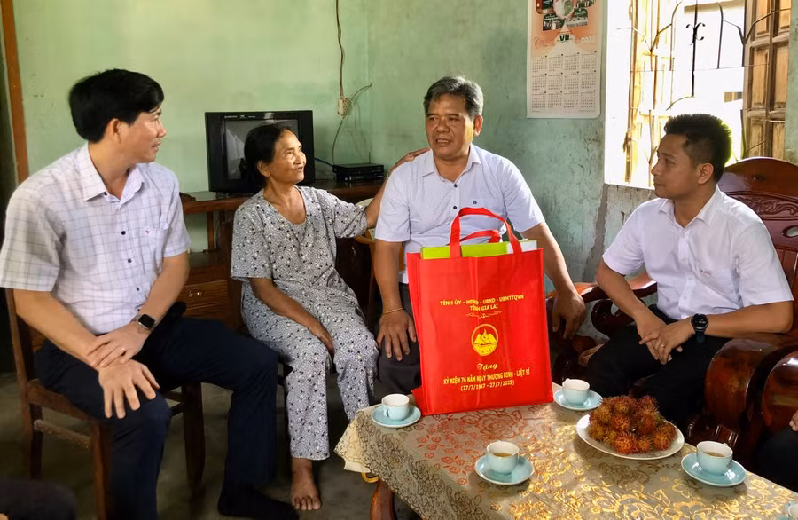 Chủ tịch Ủy ban MTTQ Việt Nam tỉnh Hồ Văn Điềm (thứ 2 từ phải qua) và Bí thư Huyện ủy Mang Yang Trần Đình Hiệp (ngoài cùng bên trái) tặng quà bà Đinh Thị Her. Ảnh: Anh Huy