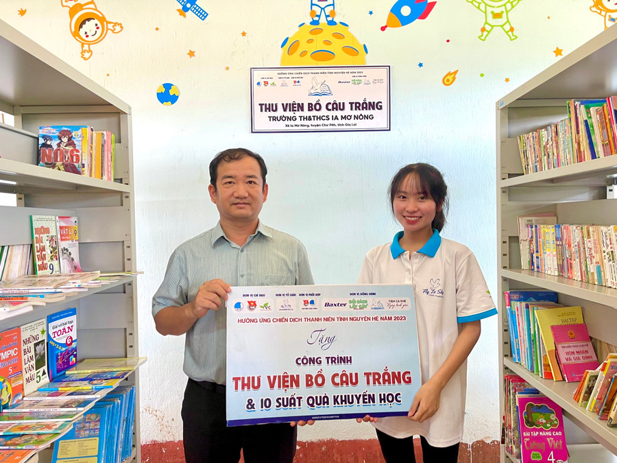 Đại diện nhóm từ thiện Fly To Sky trao bảng tượng trưng công trình “Thư viện Bồ câu trắng” cho Trường Tiểu học và THCS Ia Mơ Nông. Ảnh: Anh Huy