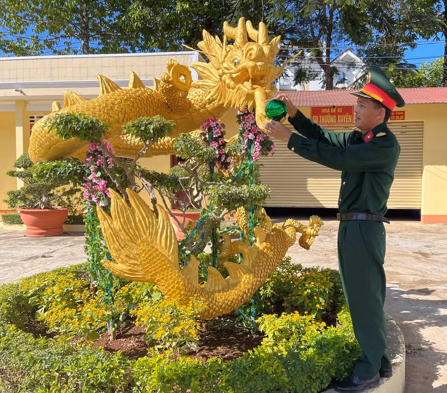 Thiếu tá Hùng bên linh vật rồng đã hoàn thiện. Ảnh: P.D