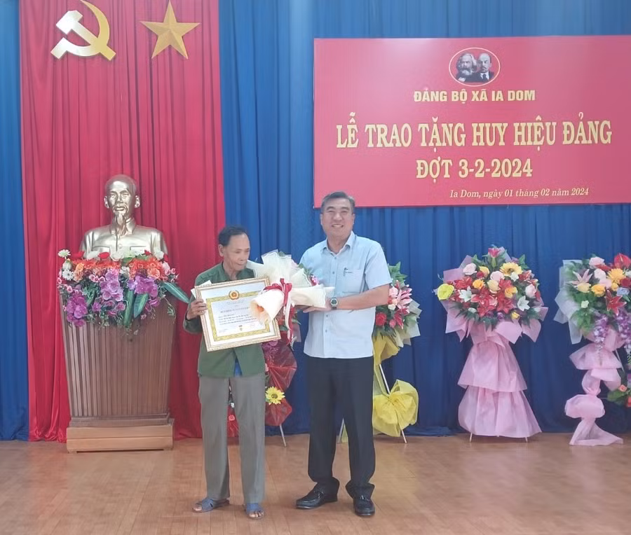 Ông Siu Hluan đón nhận Huy hiệu 50 năm tuổi Đảng từ Chủ tịch UBND huyện Đức Cơ Vũ Mạnh Định. Ảnh: P.D