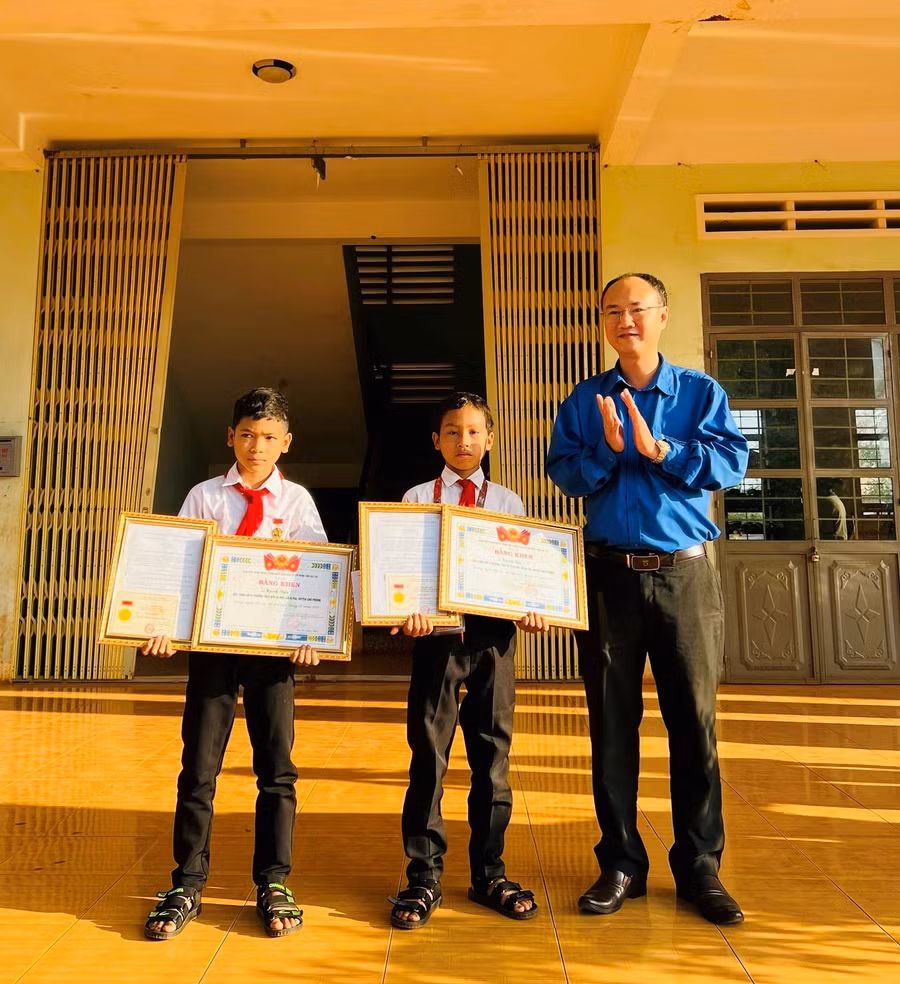 Thừa uỷ quyền của Trung ương Đoàn TNCS Hồ Chí Minh, Phó Bí thư Thường trực Tỉnh Đoàn Phan Hồ Giang (bìa trái) trao tặng Huy hiệu “Tuổi trẻ dũng cảm” cho 2 em Kpuih Sân và Kpuih Dấu. Ảnh: Minh Sang