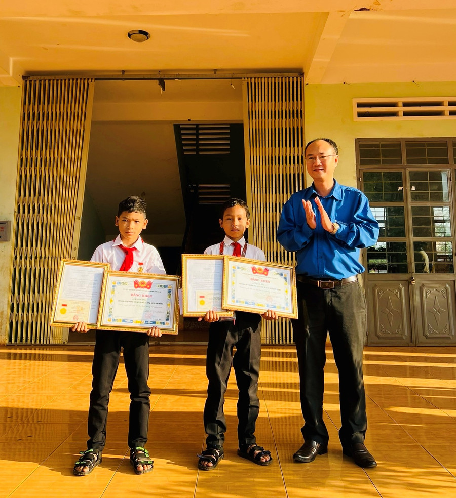 Thừa uỷ quyền của Trung ương Đoàn TNCS Hồ Chí Minh, Phó Bí thư Thường trực Tỉnh Đoàn Phan Hồ Giang (bìa trái) trao tặng Huy hiệu “Tuổi trẻ dũng cảm” cho 2 em Kpuih Sân và Kpuih Dấu. Ảnh: Minh Sang