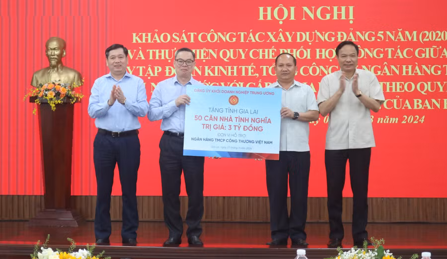 Phó Bí thư Tỉnh ủy Rah Lan Chung (thứ 2 từ phải qua) đại diện nhận bảng tượng trưng hỗ trợ 50 căn nhà tình nghĩa từ đại diện Đảng ủy Khối Doanh nghiệp Trung ương và Ngân hàng TMCP Công thương Việt Nam. Ảnh: P.D