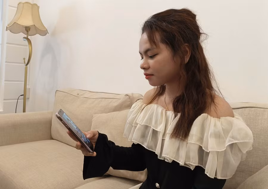 Chị Rơ Ô H'Kiêu tranh thủ thời gian nghe podcast trong lúc đợi bạn đến quán cà phê. Ảnh: Đồng Lai Chị Rơ Ô H'Kiêu tranh thủ thời gian nghe podcast trong lúc đợi bạn đến quán cà phê. Ảnh: Đồng Lai