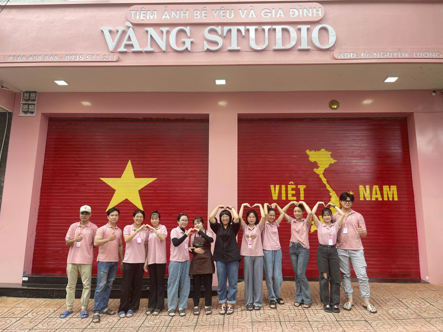 Chị Nguyễn Thị Phúc Lợi (áo đen) và toàn thể nhân viên check in sau khi hoàn thành lá cờ và bản đồ Việt Nam. Ảnh: Đồng Lai