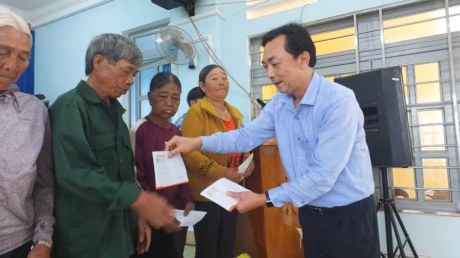 Ông Lương Văn Danh- Phó Tổng Biên tập Báo Gia Lai tặng quà cho người dân xã A Dơk. Ảnh: Nguyễn Diệp