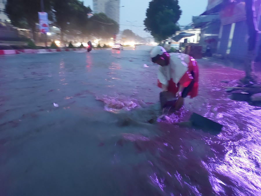 Lượng nước mưa lớn và chảy xiết buộc người dân phải dọn cống thoát nước để hạn chế tràn vào nhà. Ảnh: Nguyễn Diệp Lượng nước mưa lớn và chảy xiết buộc người dân phải dọn cống thoát nước để hạn chế tràn vào nhà. Ảnh: Nguyễn Diệp